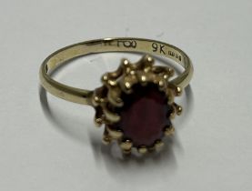 A 9CT YELLOW GOLD AND GARNET RING, SIZE K