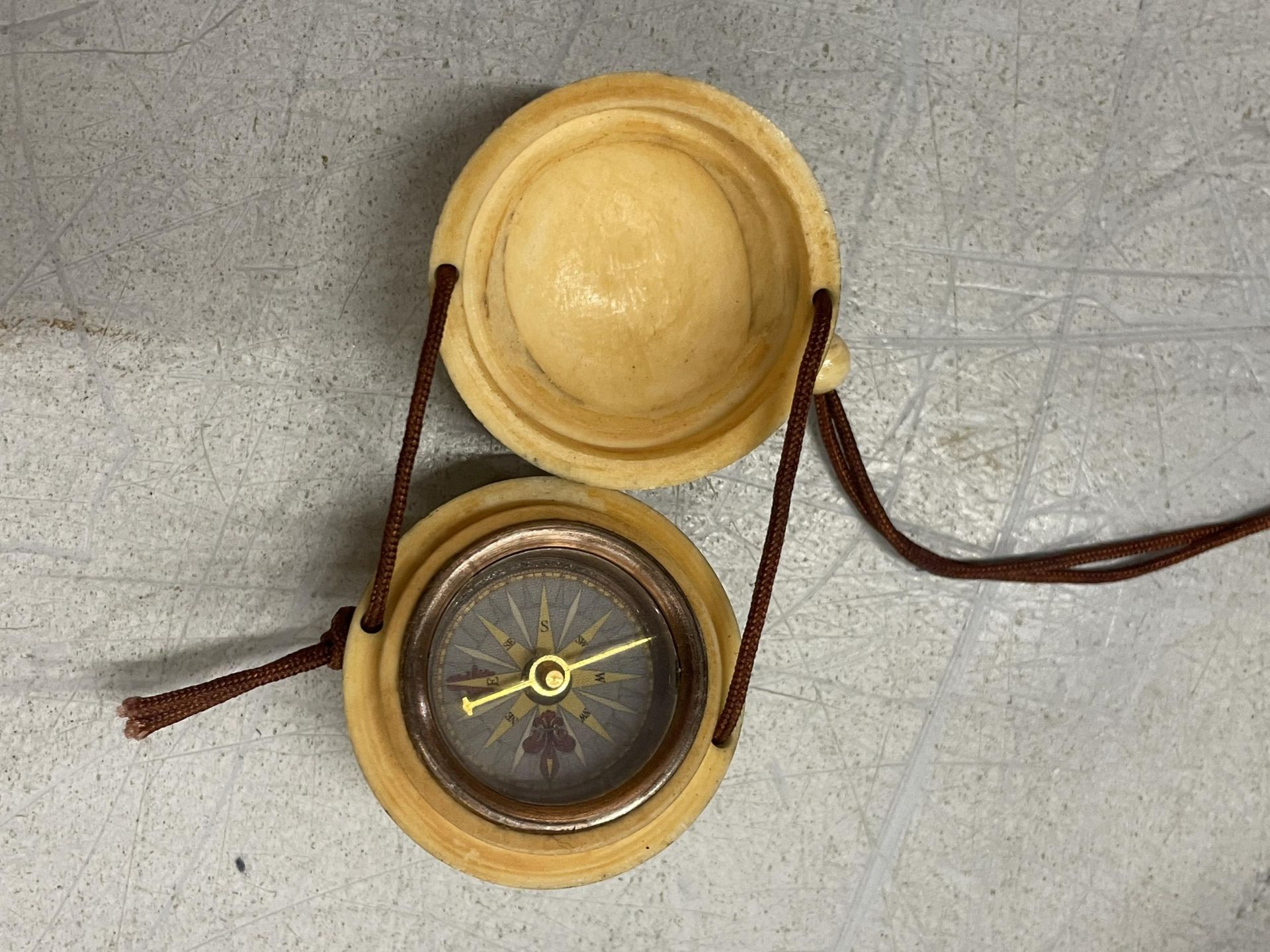 A BONE CARVED COMPASS ON A CORD - Bild 3 aus 3