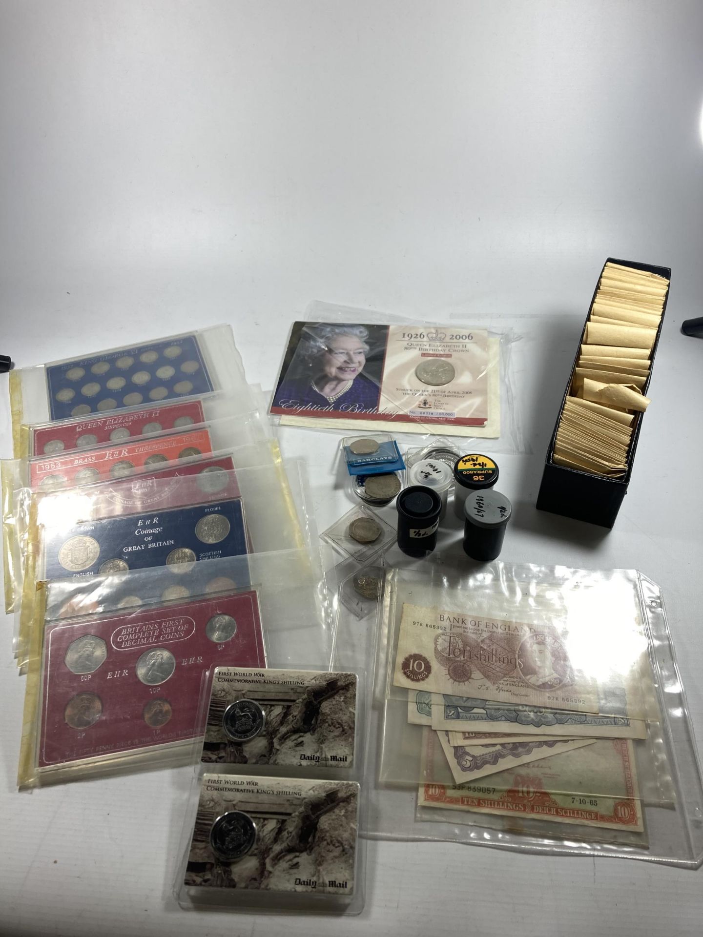 A MIXED LOT OF COINS TO INCLUDE SIX CASED UK SETS , VARIOUS UK COINS IN TUBS , PLUS A BLACK