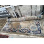 A LARGE PEACH AND FLORAL PATTERNED CHINESE FRINGED RUG (370CM X 280CM)