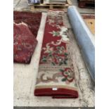 A LARGE RED PATTERNED RUG