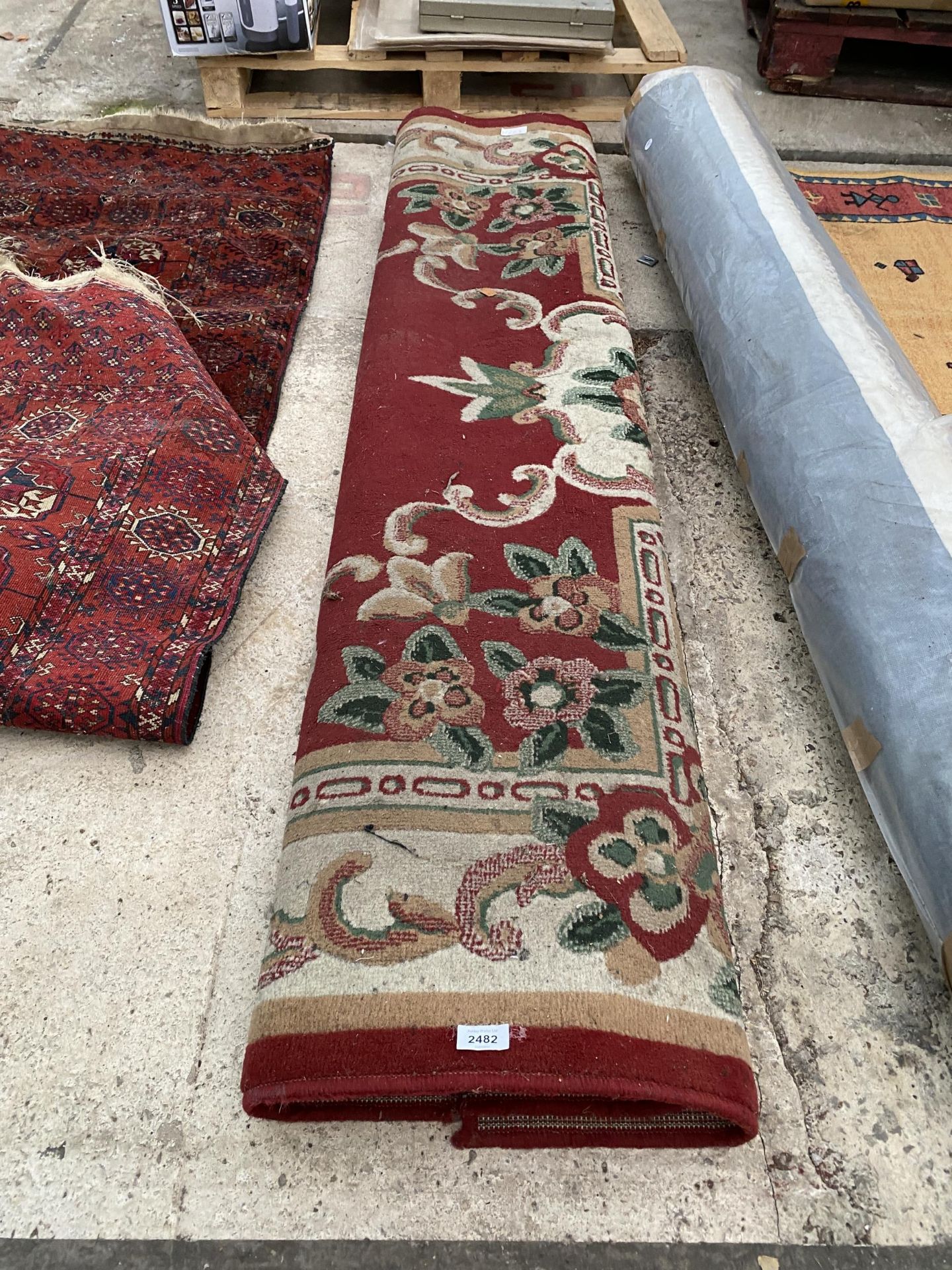 A LARGE RED PATTERNED RUG