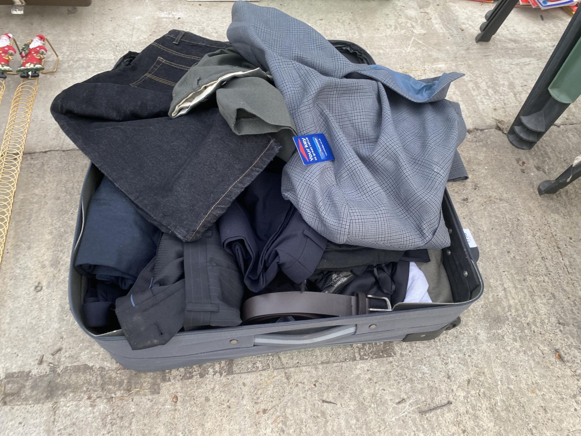 A SUITCASE CONTAINING AN ASSORTMENT OF CLOTHING