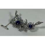 A SILVER ART DECO SAPPHIRE STYLE BLUE AND CLEAR STONE FLORAL BROOCH