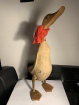 A LARGE WOODEN DUCK FIGURE WITH A RED SCARF