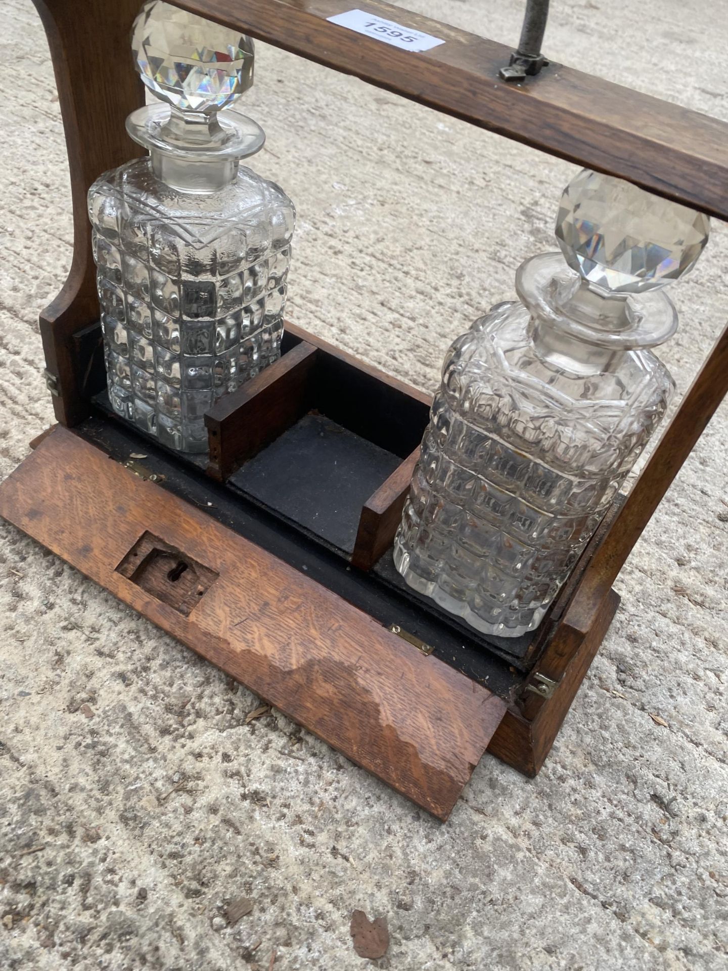 A VINTAGE OAK TANTALUS DECANTER HOLDER WITH TWO GLASS DECANTERS AND SILVER PLATE DETAIL - Bild 2 aus 2