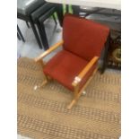 A RETRO CHILDS ROCKING CHAIR WITH RED UPHOLSTERY