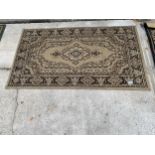 A SMALL BEIGE PATTERNED RUG