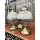 A PAIR OF BRASS EFFECT TABLE LAMPS WITH GLASS SHADES
