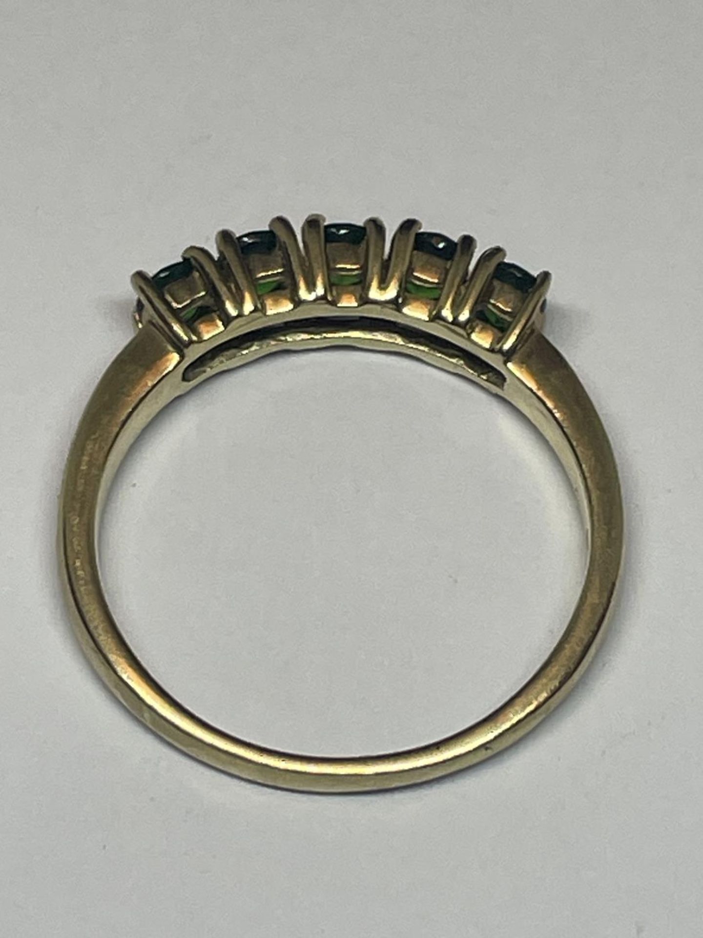A 9 CARAT GOLD RING WITH FIVE IN LINE EMERALDS SIZE N/0 - Image 3 of 3