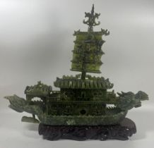 A CHINESE CARVED JADE TYPE GREEN HARDSTONE DRAGON DESIGN BOAT SCULPTURE ON WOODEN BASE, LENGTH 34CM