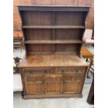 A REPRODUCTION OAK DRESSER COMPLETE WITH RACK, THE BASE ENCLOSING TWO DRAWERS AND TWO CUPBOARDS, 49"