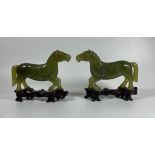 A PAIR OF JADE STYLE HARDSTONE HORSES ON CARVED WOODEN BASES, HEIGHT 12 CM