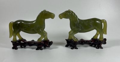 A PAIR OF JADE STYLE HARDSTONE HORSES ON CARVED WOODEN BASES, HEIGHT 12 CM