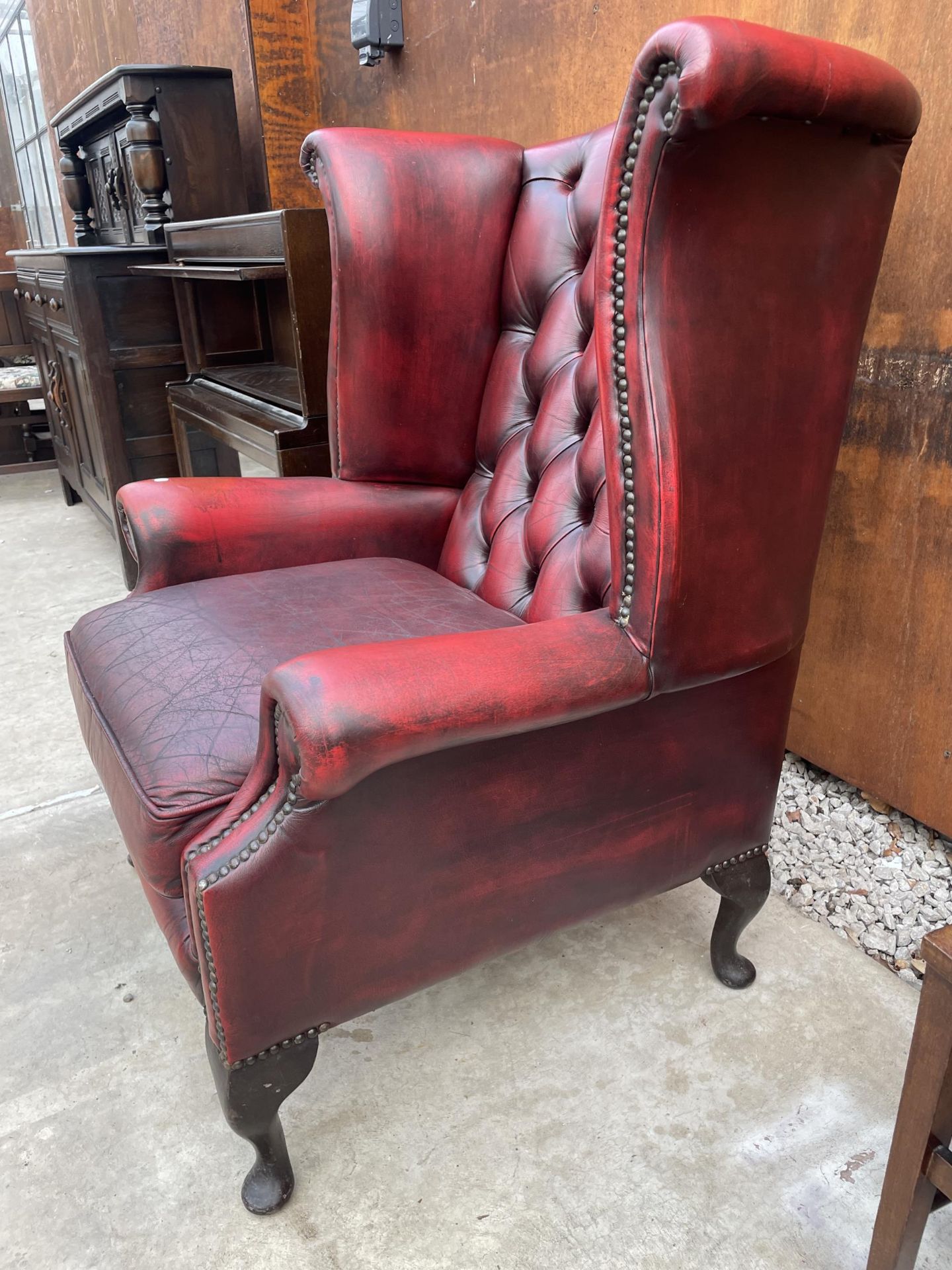 AN OXBLOOD WINGED FIRESIDE CHAIR ON CABRIOLE LEGS WITH BUTTON-BACK AND STUD DECORATION - Image 4 of 4