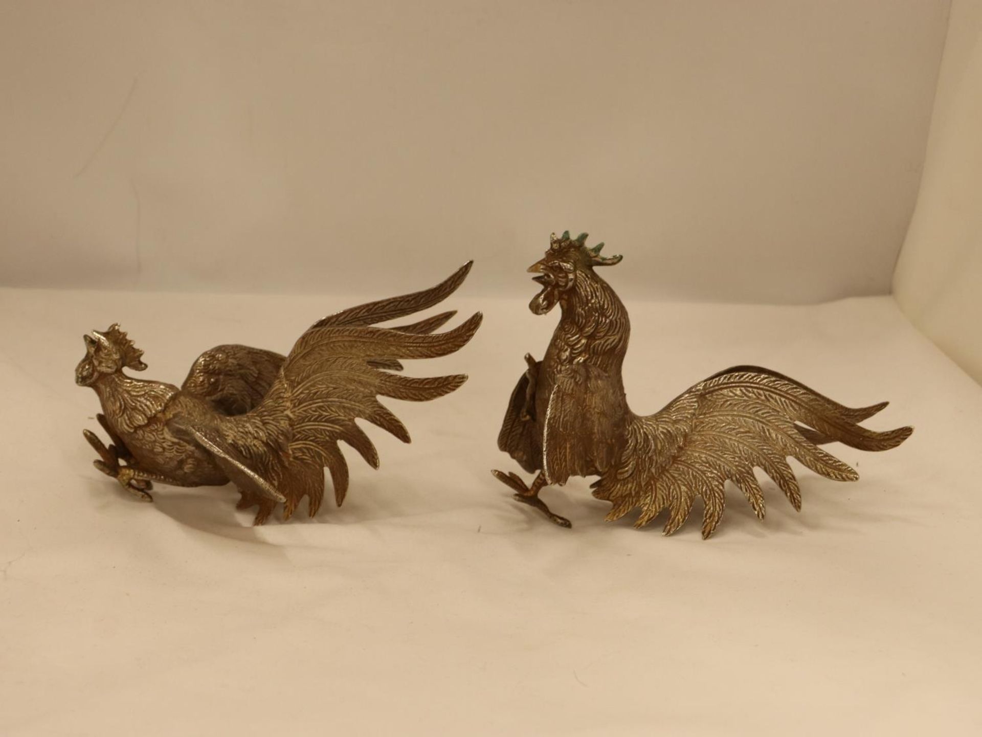 A PAIR OF VINTAGE WHITE METAL FIGHTING COCK FIGURES