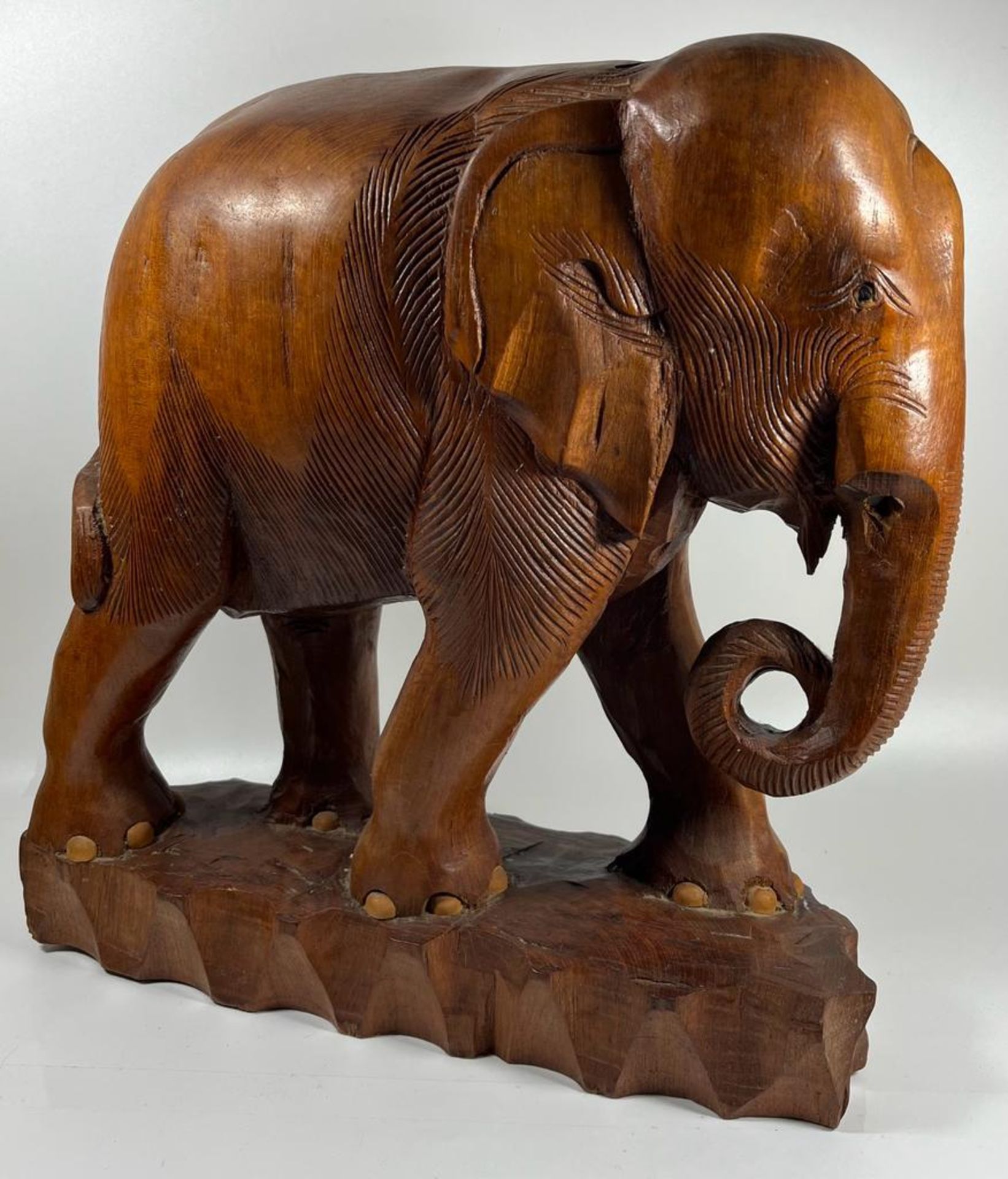 A LARGE AND HEAVY VINTAGE CARVED SOLID TEAK ELEPHANT MODEL, LIKELY CARVED FROM ONE PIECE OF TEAK