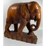 A LARGE AND HEAVY VINTAGE CARVED SOLID TEAK ELEPHANT MODEL, LIKELY CARVED FROM ONE PIECE OF TEAK