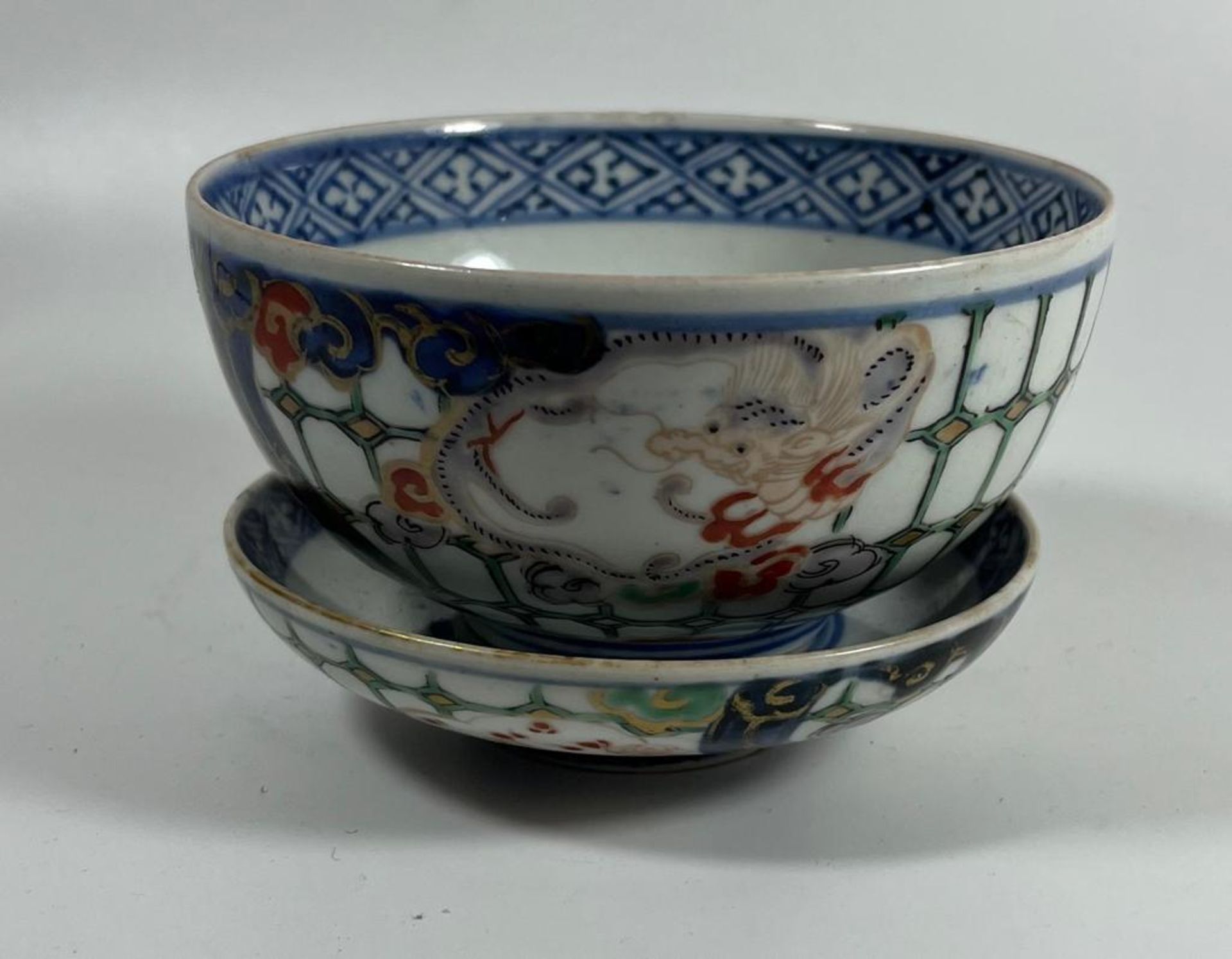 A 19TH CENTURY JAPANESE IMARI DRAGON BOWL AND MATCHING SAUCER, BOTH WITH MATCHING MOTIFS AND DESIGN,
