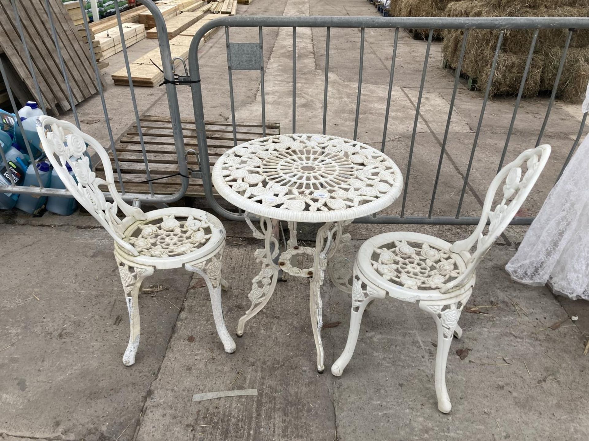 A VINTAGE STYLE METAL BISTRO SET COMPRISING OF A ROUND TABLE AND TWO CHAIRS
