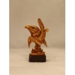 A WOODEN CARVED EAGLE'S HEAD ON A PLINTH, HEIGHT 25CM