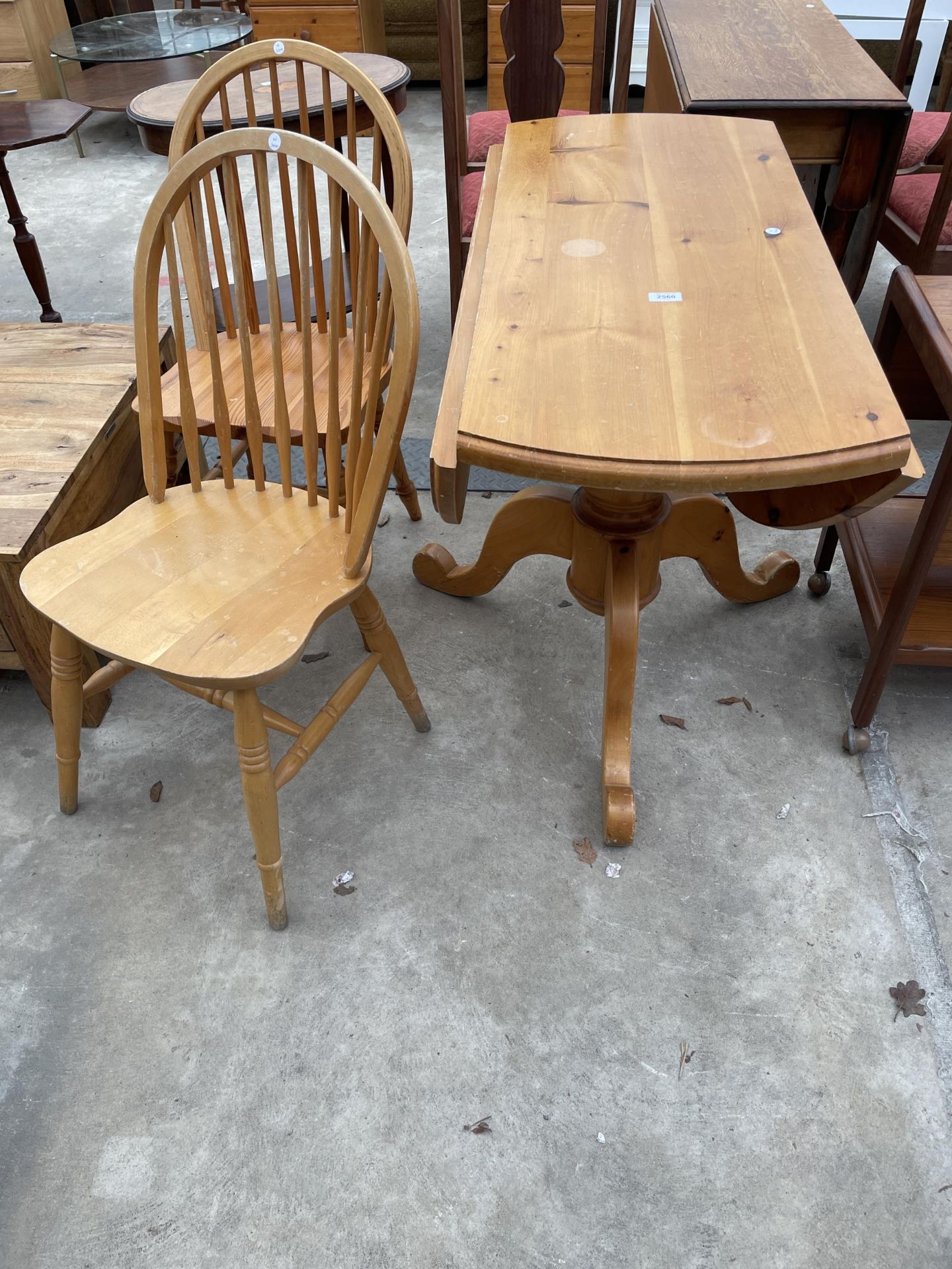 A PINE 42" DIAMETER DROP-LEAF DINING TABLE ON TRIPOD BASE AND A PAIR OF WINDSOR STYLE CHAIRS