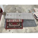 A SMALL RED PATTERNED RUG AND A MODERN GREY RUG