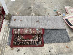 A SMALL RED PATTERNED RUG AND A MODERN GREY RUG
