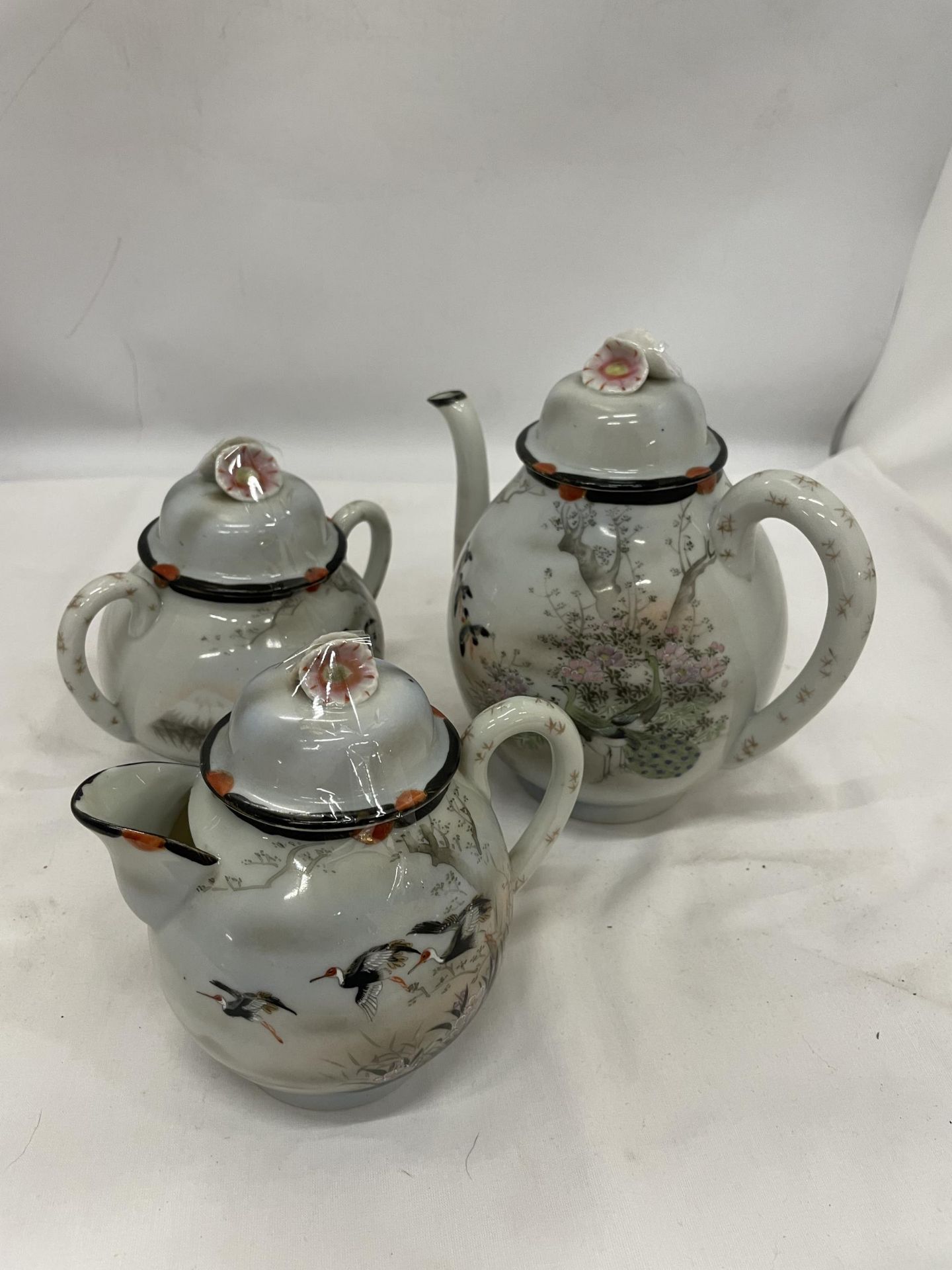 AN ORIENTAL TEAPOT, CREAM JUG AND SUGAR BOWL