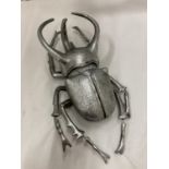 A LARGE SILVER COLOURED WALL HANGING BEETLE