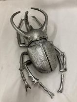 A LARGE SILVER COLOURED WALL HANGING BEETLE