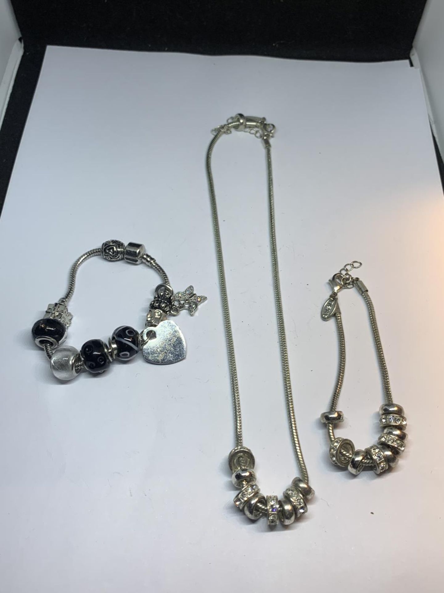 THREE PANDORA STYLE ITEMS WITH CHARMS TO INCLUDE A NECKLACE AND TWO BRACELETS