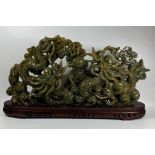 A LARGE CHINESE CARVED JADE TYPE GREEN HARDSTONE SCULPTURE DEPICTING TWO DRAGONS FIGHTING OVER THE