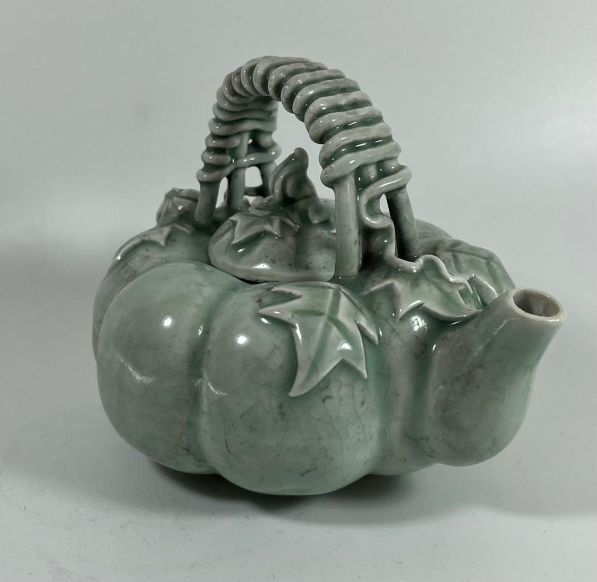 A CHINESE CELADON GLAZE TEAPOT WITH BRAIDED DESIGN HANDLE, HEIGHT 11 CM