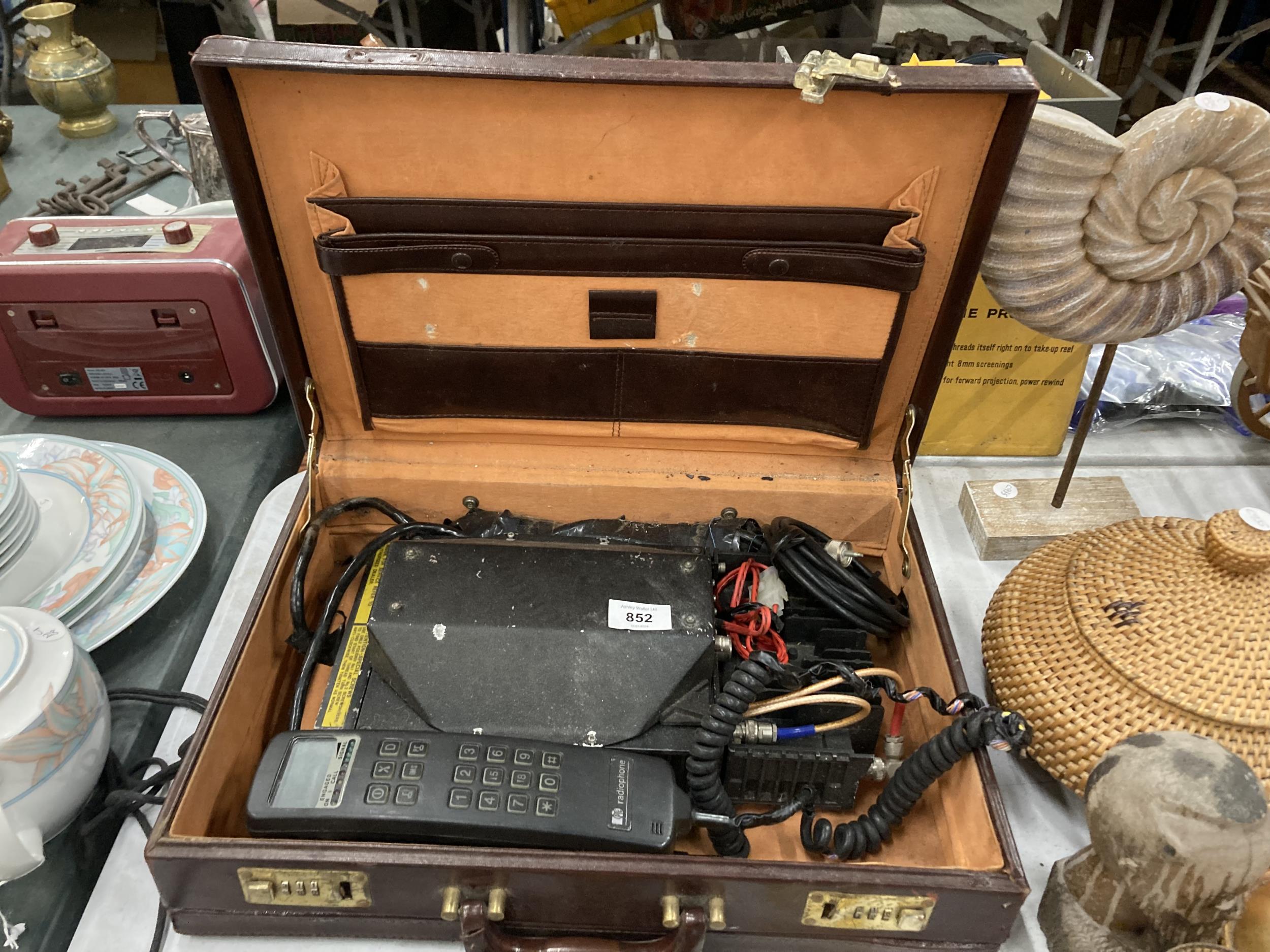 A VINTAGE MOBILE PHONE WITH CHARGER IN A BRIEFCASE