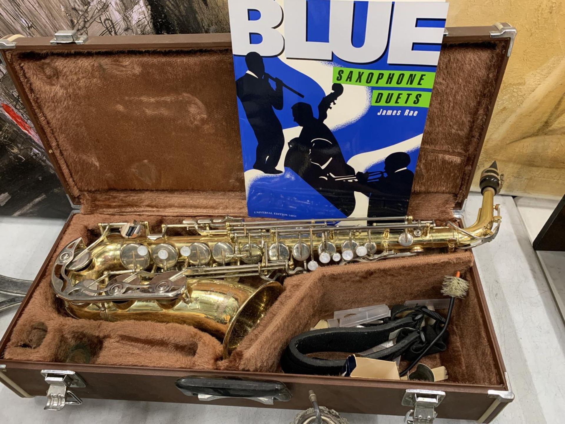 A YAMAHA SAXOPHONE WITH CASE AND A TEACHING BOOK