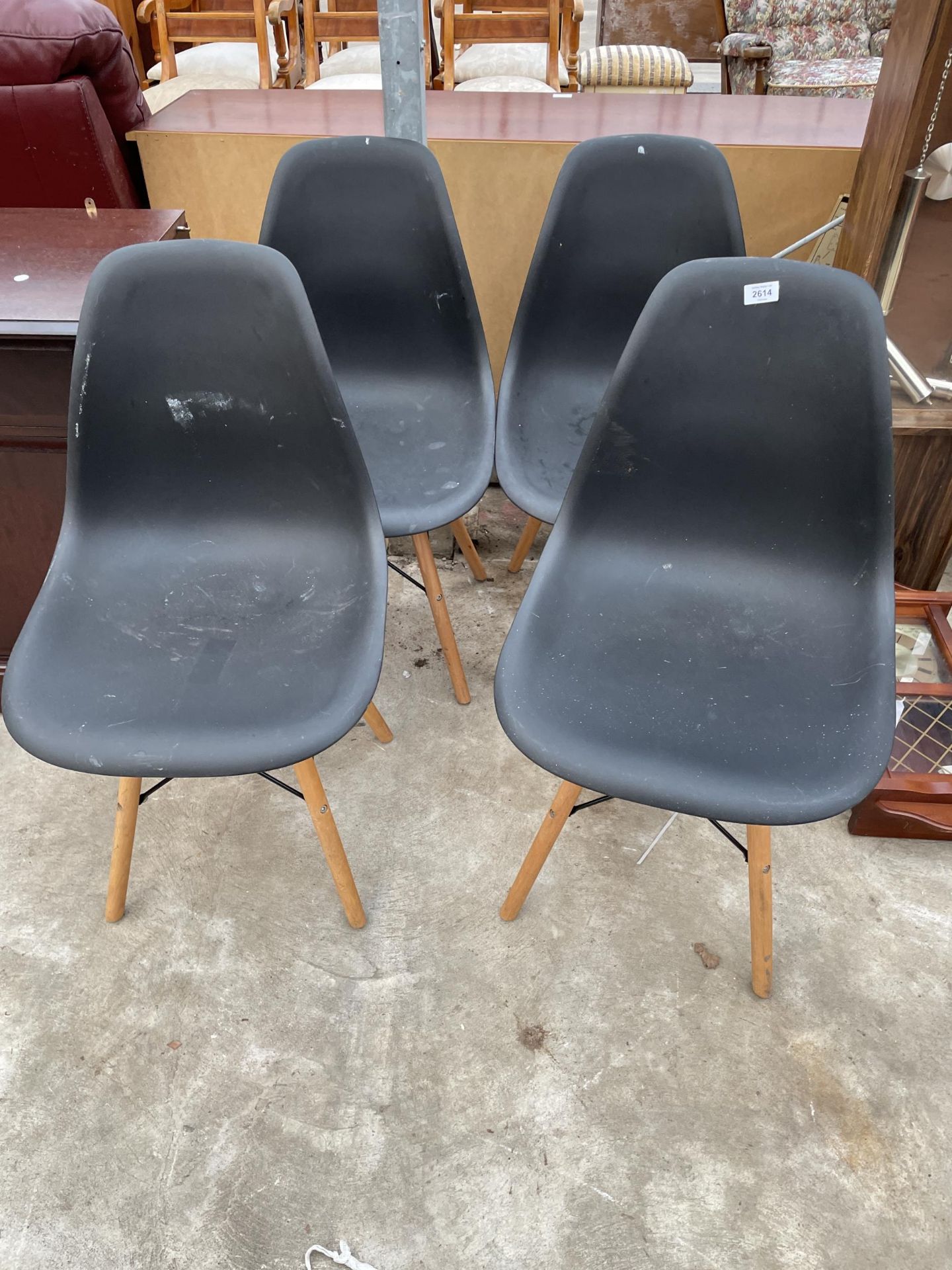 A SET OF FOUR MOULDED PLASTIC DINING CHAIRS ON KICK-OUT LEGS