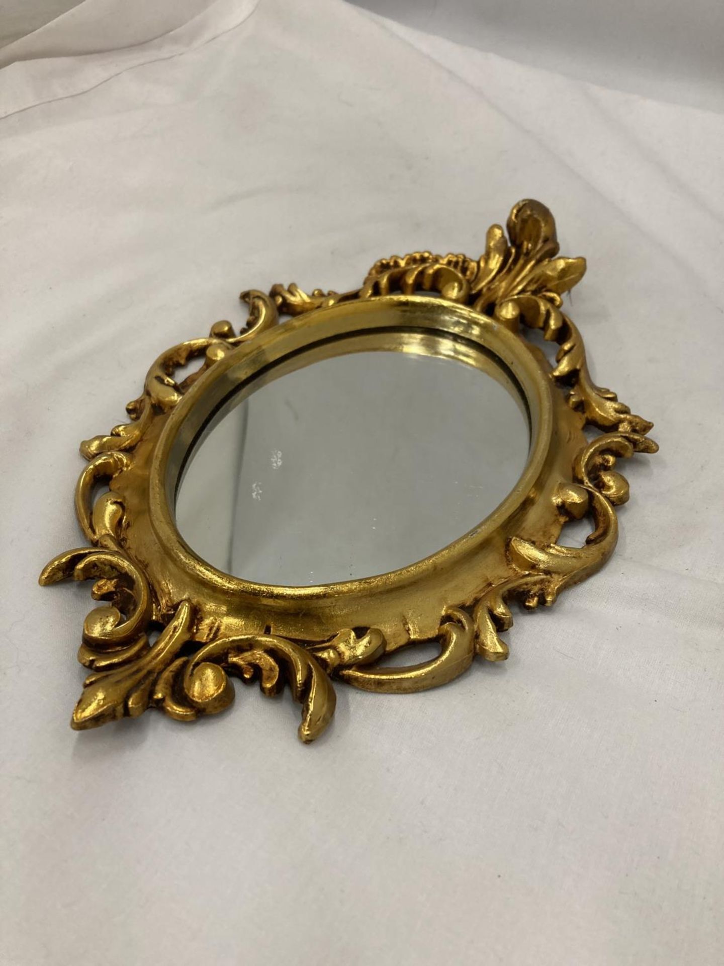 A SMALL OVAL GILT MIRROR, PLEASE NOTE THE SIZE, 19CM X 29CM - Image 3 of 4