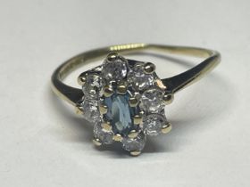 A 9 CARAT GOLD RING WITH A CENTRE BLUE TOPAZ STONE SURROUNDED BY CUBIC ZIRCONIAS SIZE I