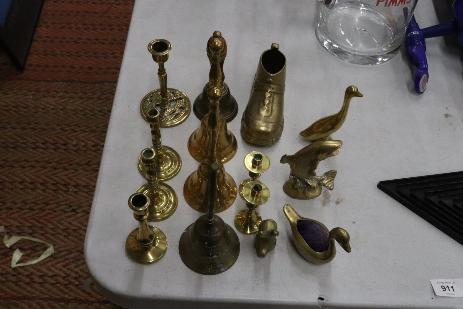 A QUANTITY OF BRASSWARE TO INCLUDE FOUR BELLS, SWAN PIN CUSHION, CANDLESTICKS, ETC.,