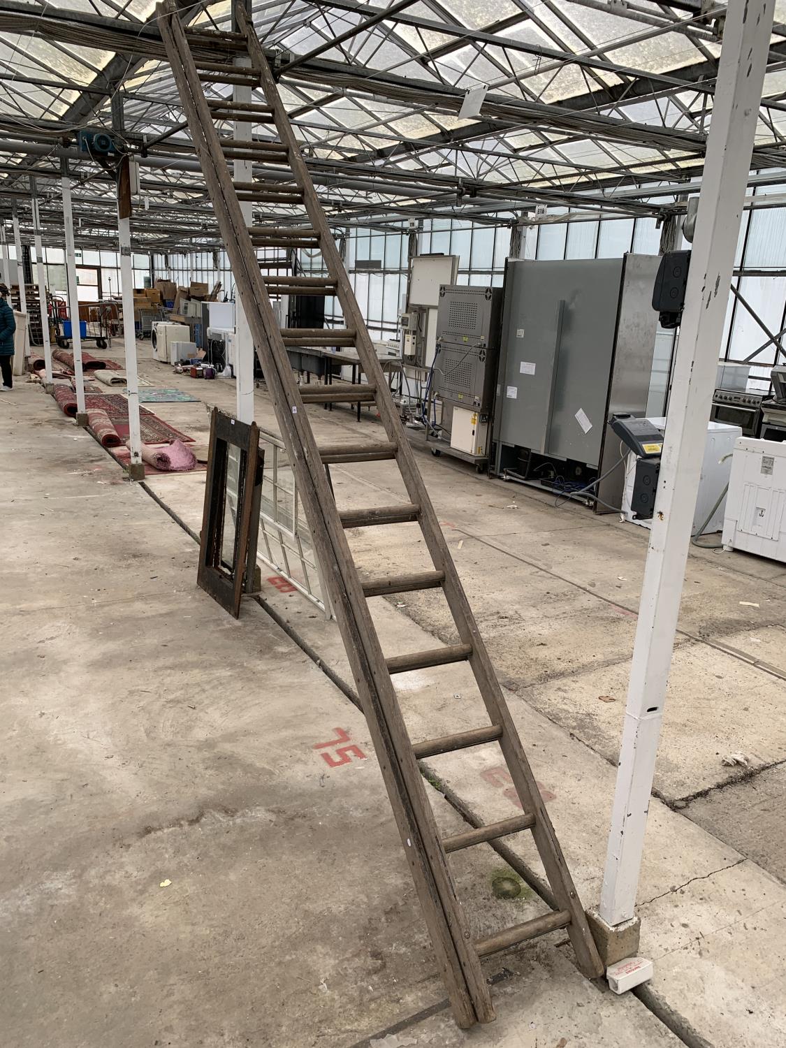 A TWO SECTION 32 RUNG WOODEN LADDER