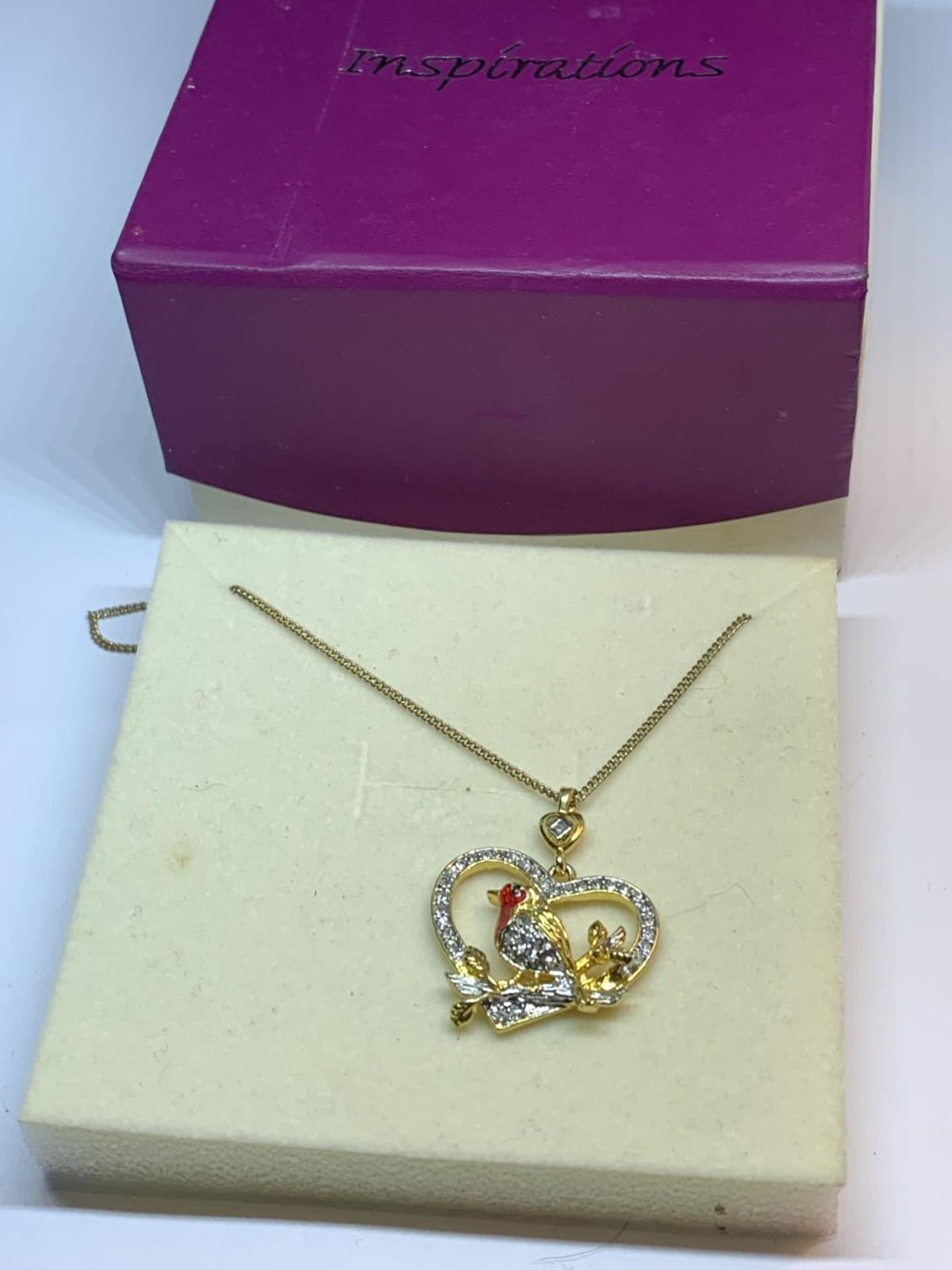 A NECKLACE WITH A CRYSTAL ROBIN PENDANT IN A PRESENTATION BOX