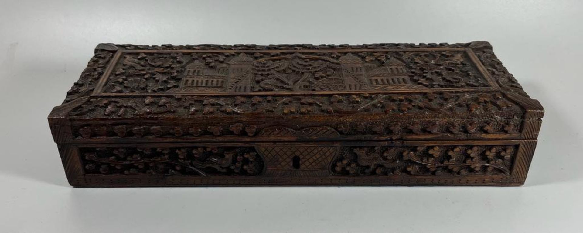 AN ANGLO INDIAN CARVED WOODEN BOX WITH TEMPLE DESIGN TOP, LENGTH 27 CM