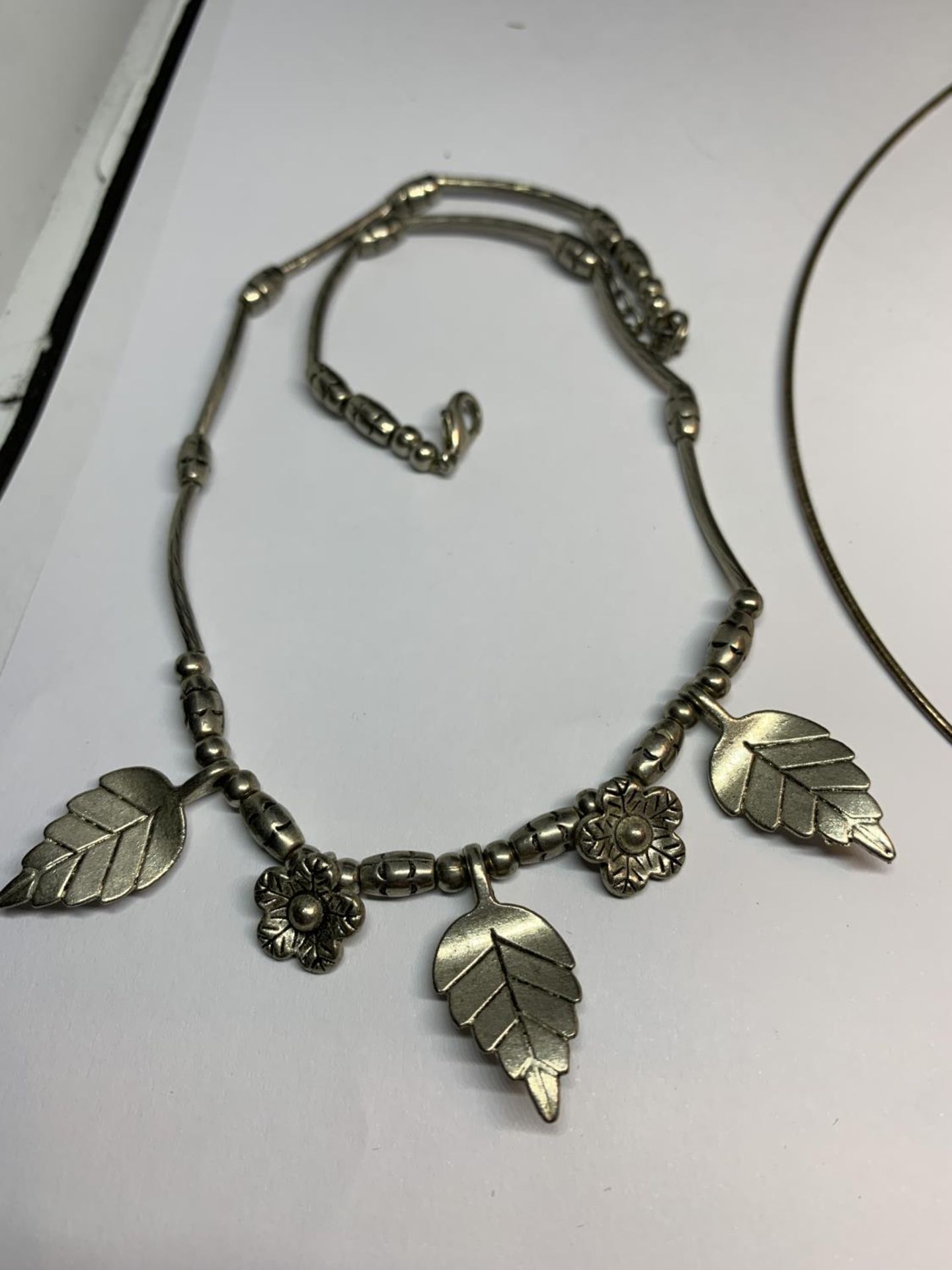 TWO SILVER NECKLACES ONE WITH LEAVES AND FLOWERS AND ONE WITH A PENDANT - Image 2 of 3