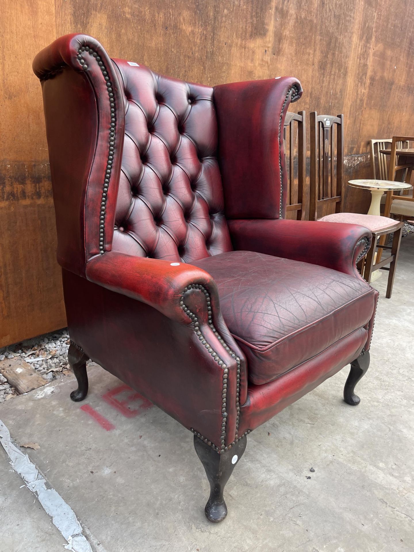 AN OXBLOOD WINGED FIRESIDE CHAIR ON CABRIOLE LEGS WITH BUTTON-BACK AND STUD DECORATION - Image 2 of 4