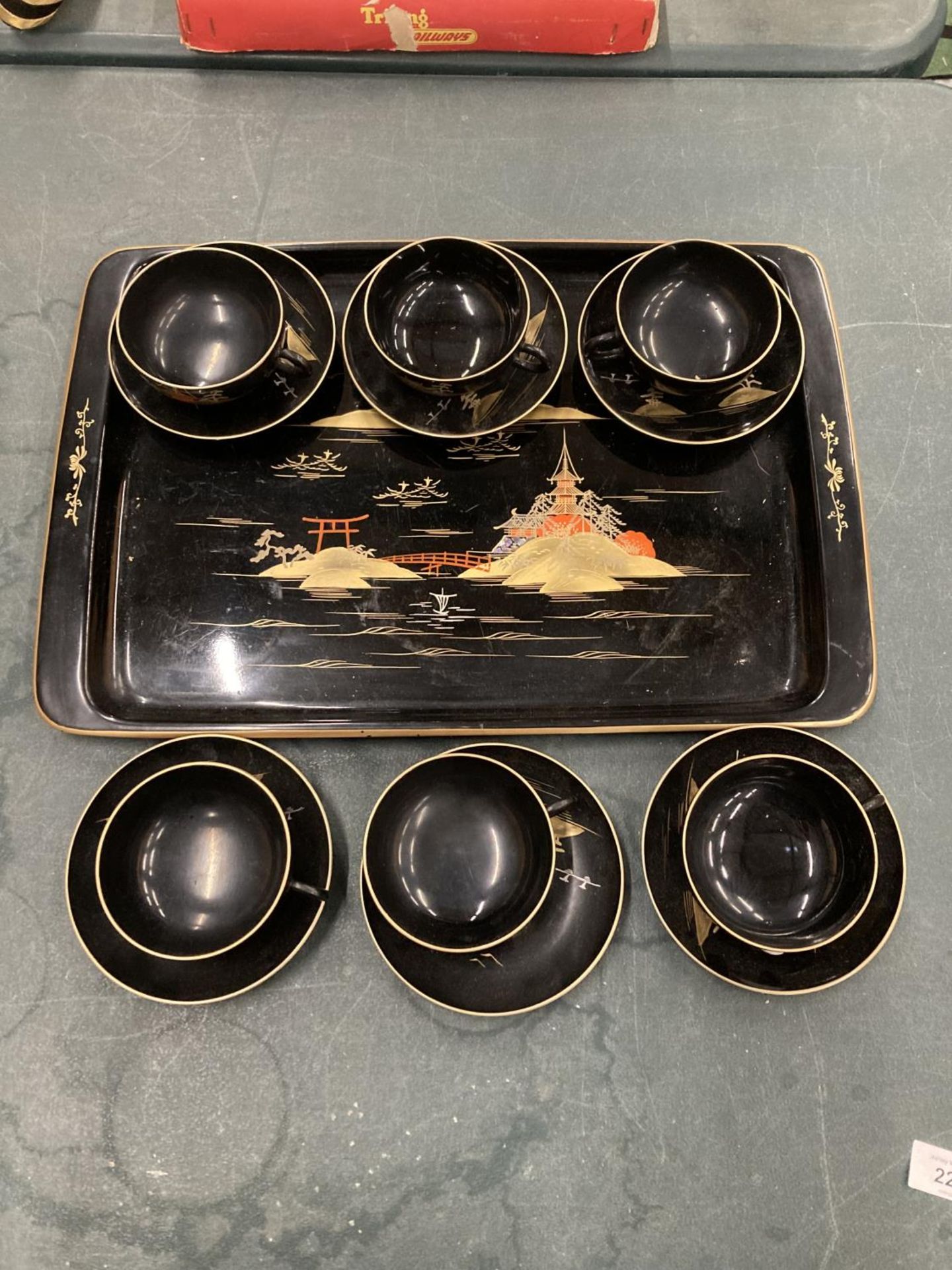 AN ORIENTAL HANDPAINTED, LACQUERED TRAY WITH SIX CUPS AND SAUCERS