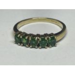 A 9 CARAT GOLD RING WITH FIVE IN LINE EMERALDS SIZE N/0