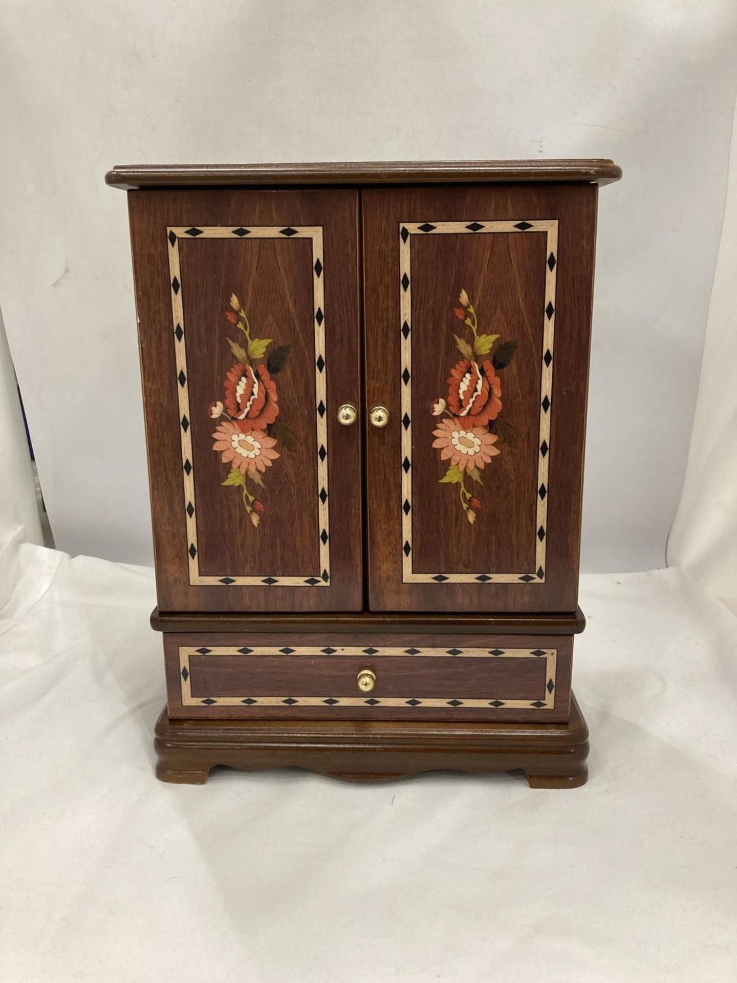 A WOODEN INLAID JEWELLERY BOX WITH DOORS AND A DRAWER