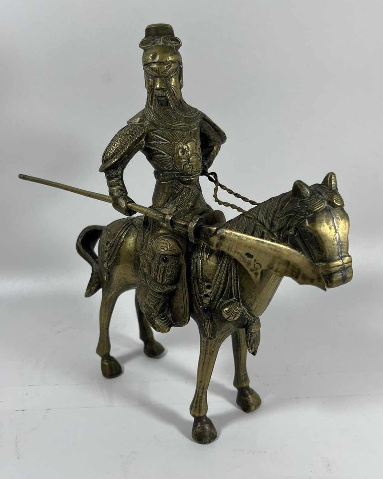 A VINTAGE CHINESE BRASS FIGURE OF A WARRIOR ON HORSEBACK WITH JEWEL DESIGN, HEIGHT 24CM