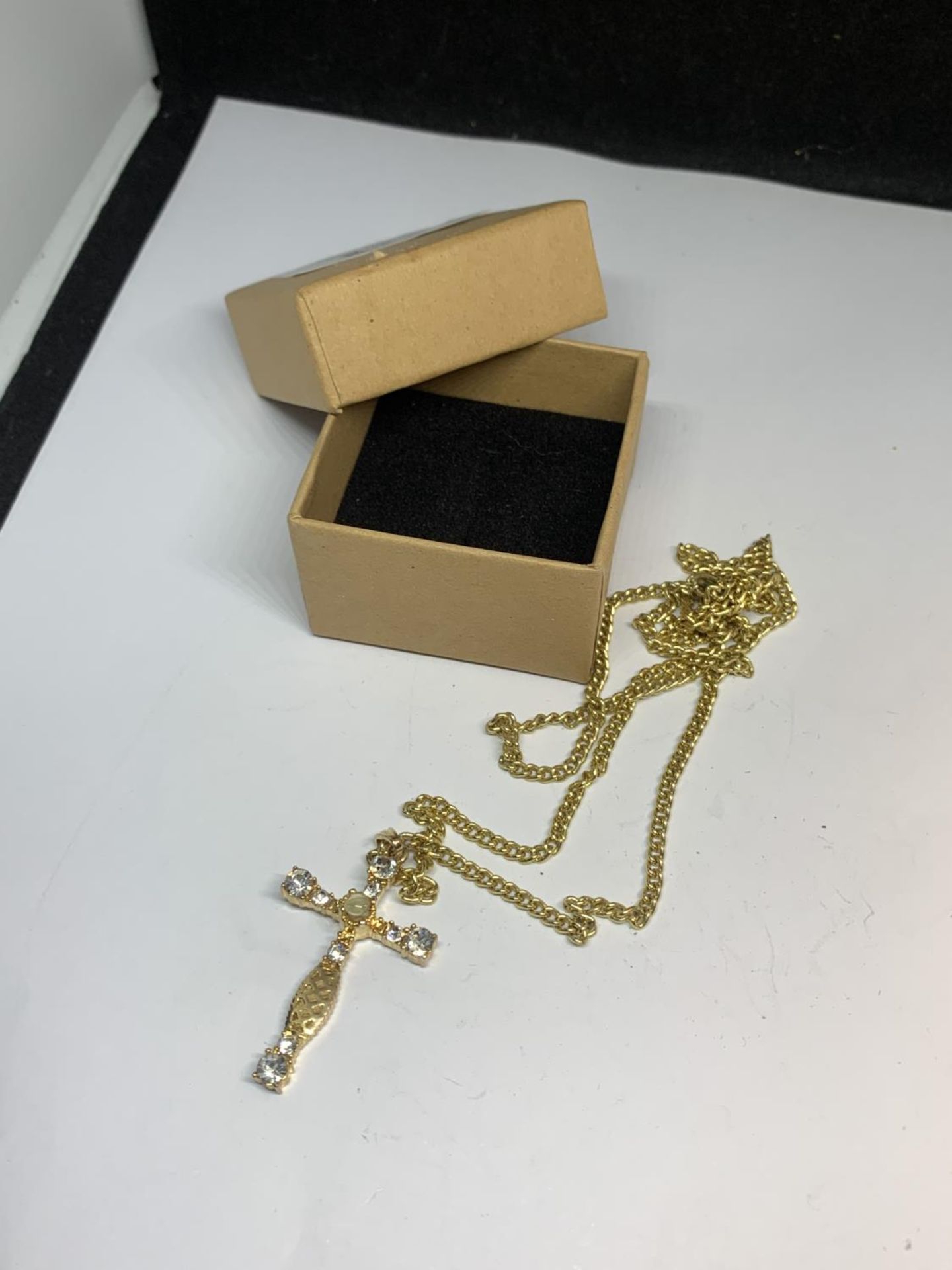 A NECKLACE WITH A CRYSTAL CROSS IN A PRESENTATION BOX